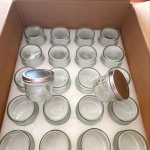 4 oz glass jars with silver lids. There are 22 of the jars.